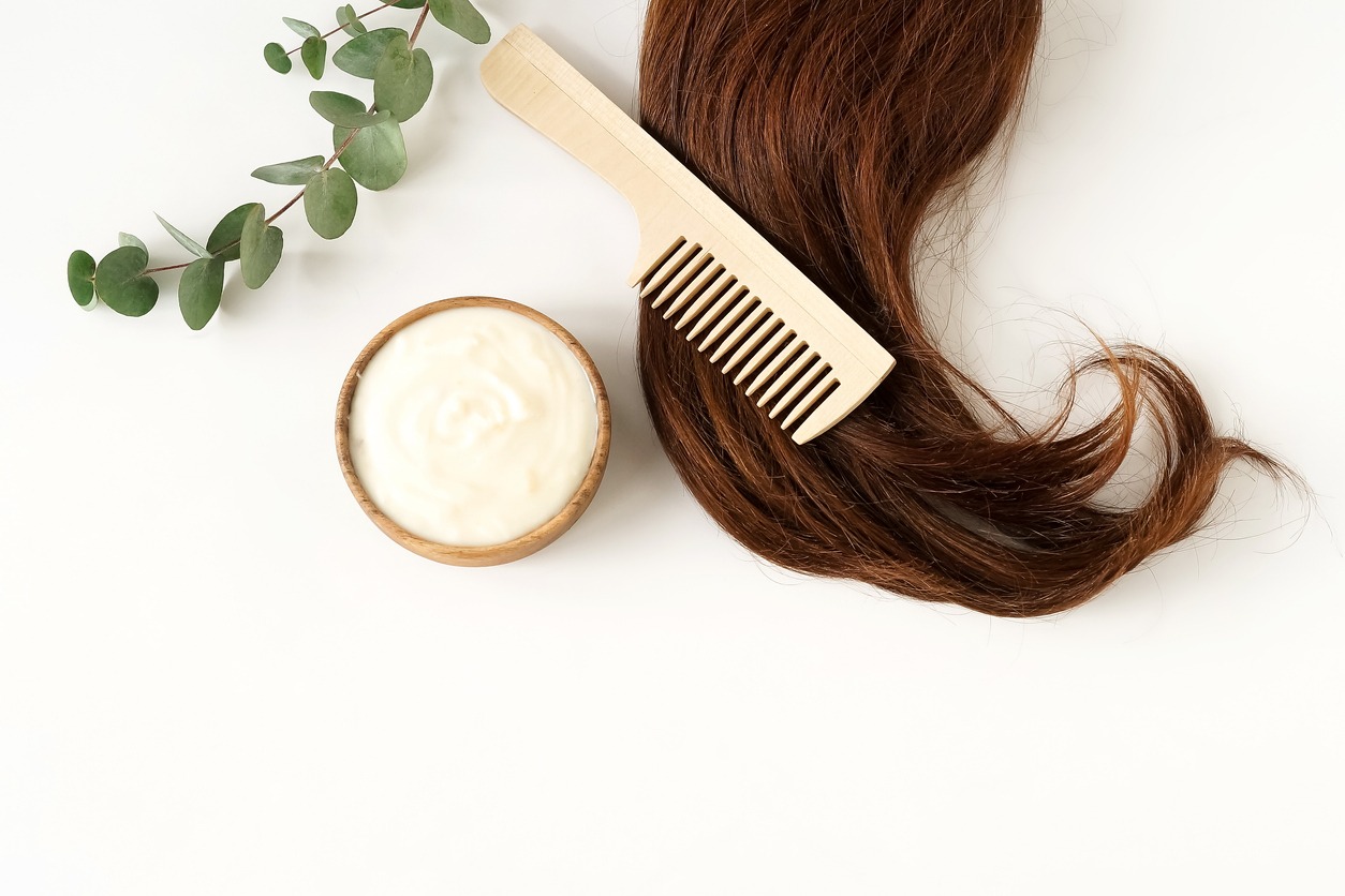 female hair, hair mask, and bamboo comb on white background top view, flat lay. copy space. Self-care concept