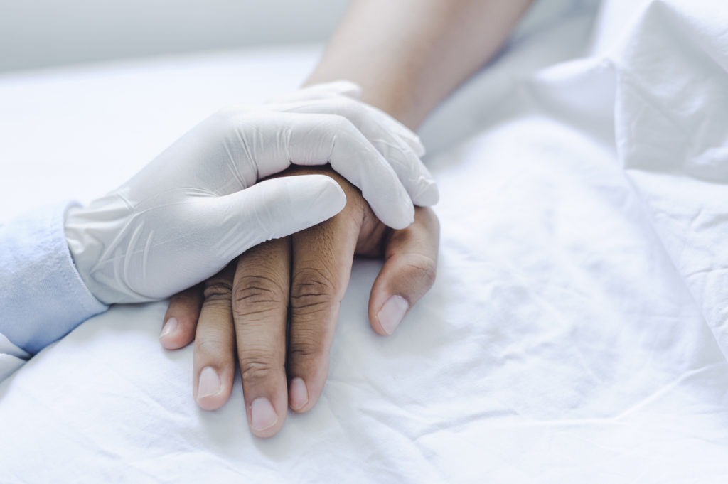 Male doctors wear medical gloves holding touching hands man patient with love, care, helping, encourage and empathy at the nursing hospital ward. healthy strong medical concept