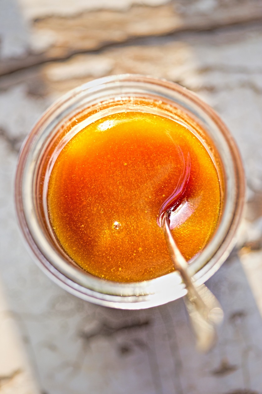 Manuka honey in the jar with spoon, morning sunlight