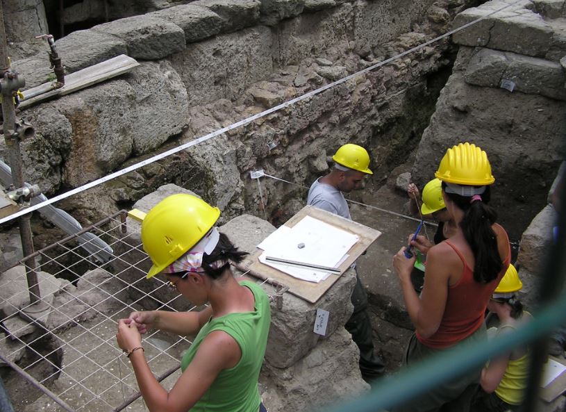 people in excavation using yellow hard hats