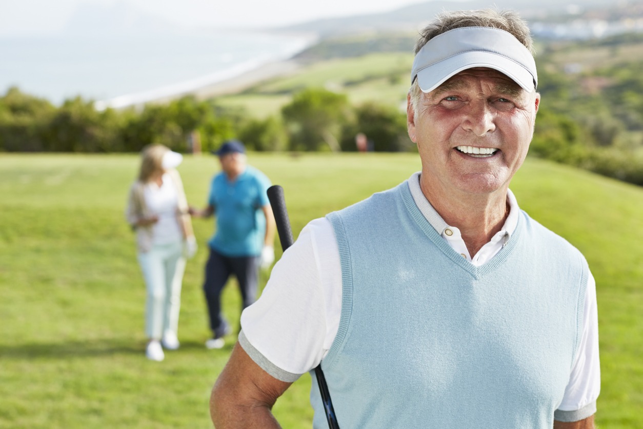 Smiling senior man on the golf course wearing visor