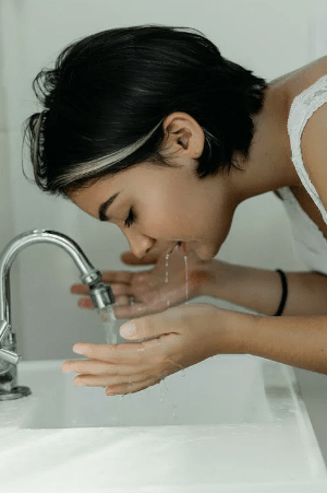 woman-washing-her-face-with-water