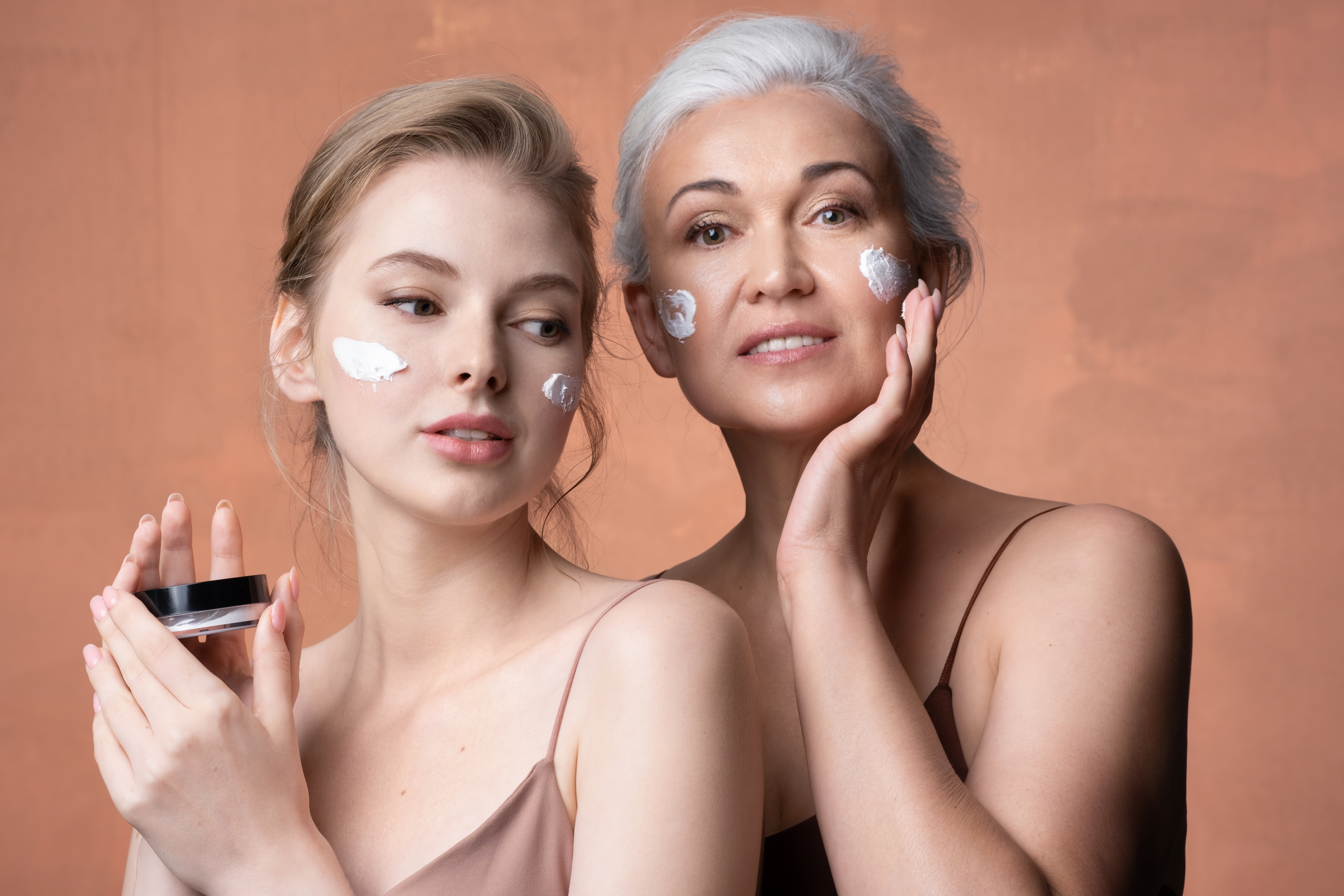 two women with different skin types applying moisturizer