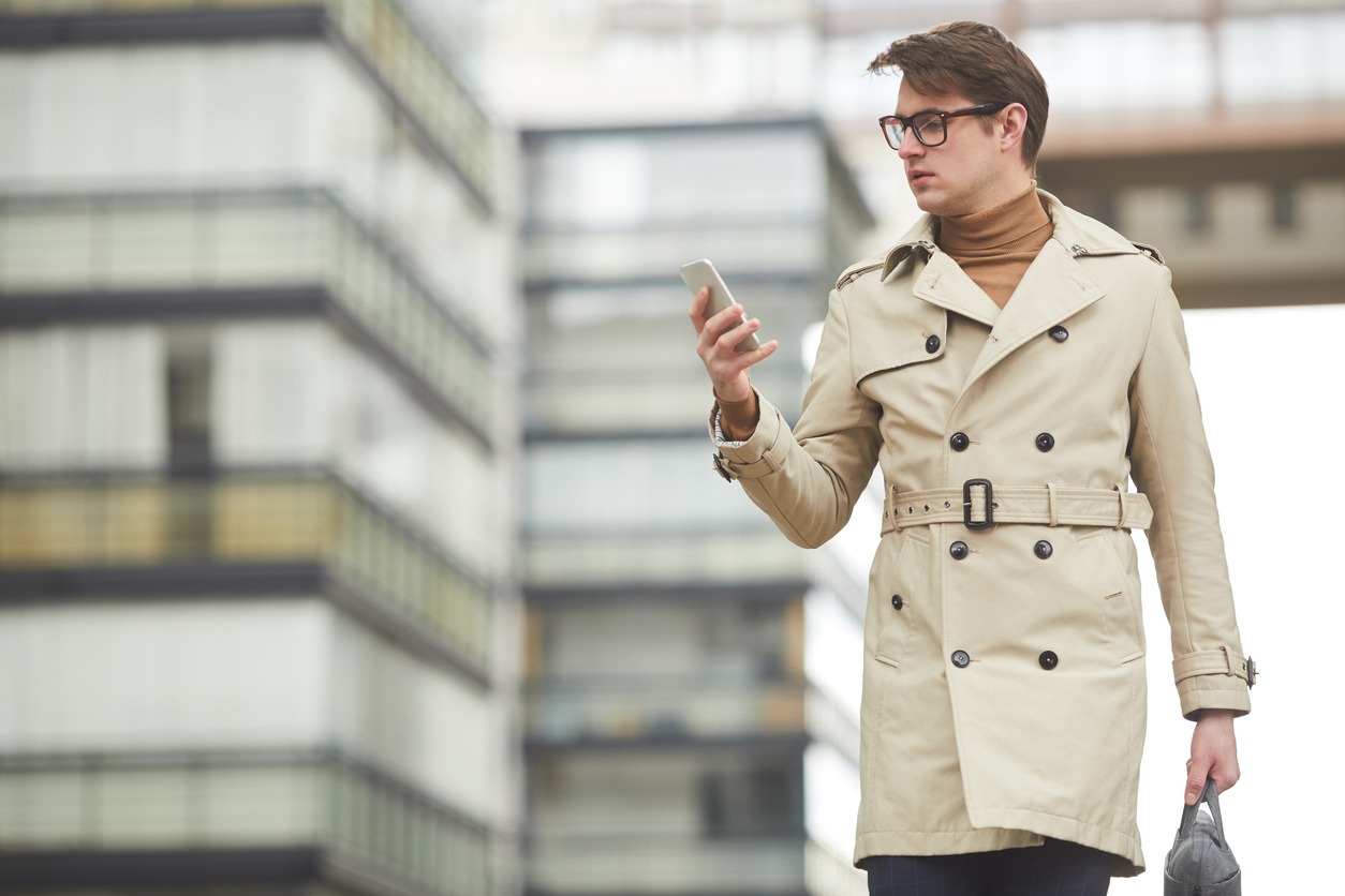 Graphic waist up portrait of modern young businessman wearing trench coat