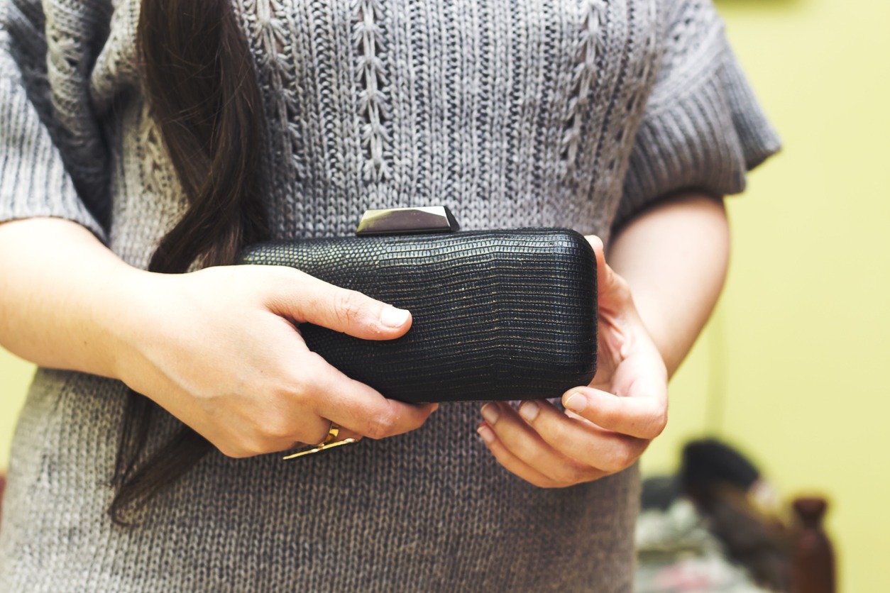Woman holding black clutch and ready for party