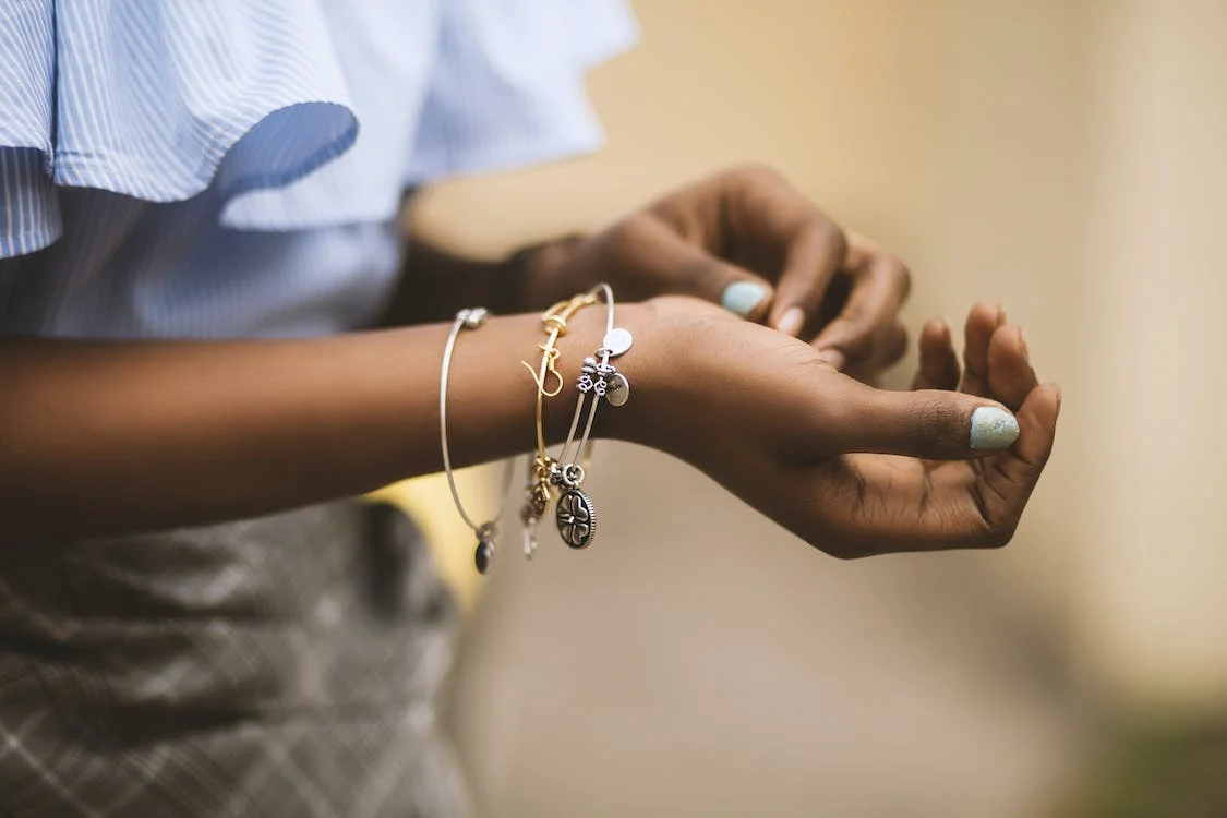 selective focus photography of a person wearing three bangles