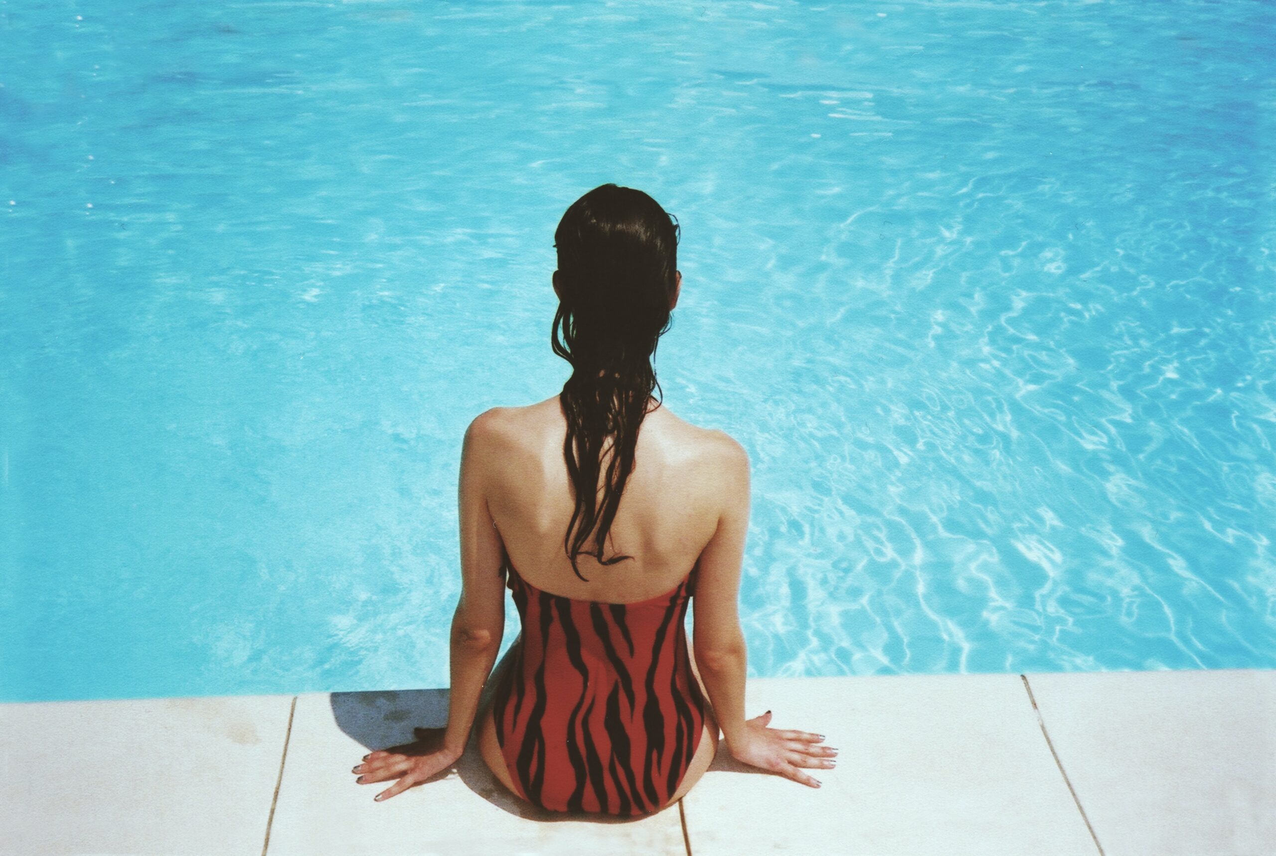 Woman in swimsuit sitting in a pool