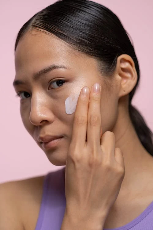 picture of a woman applying cream on face