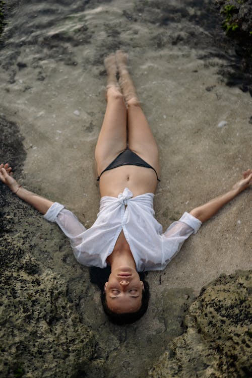 Young-woman-lying-in-shirt-and-bikini-in-seawater