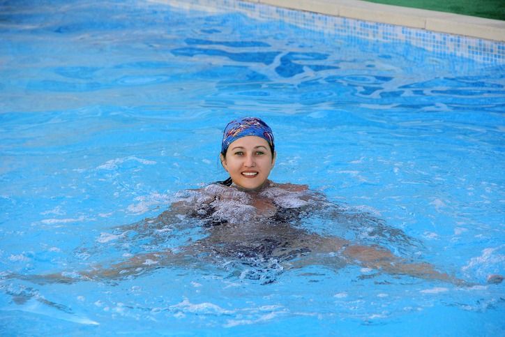 Beautiful smiling girl sailling in pool