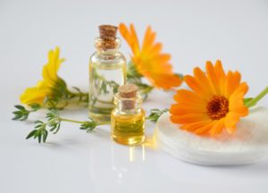 bottles-of-essential-oils-orange-flowers-yellow-flower-cotton-pads